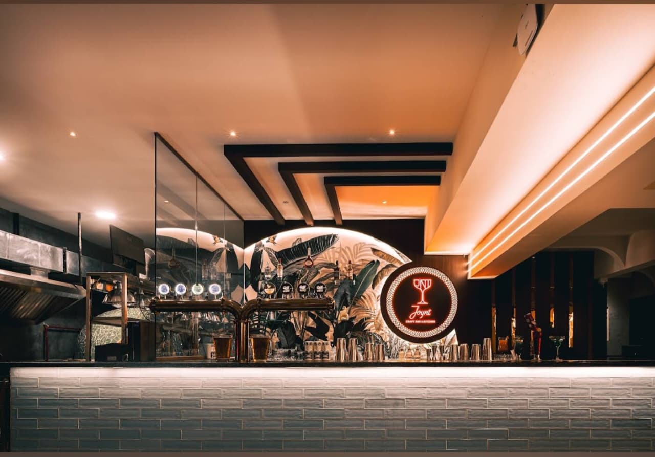 Bar counter with sculpted arch and pendant lighting